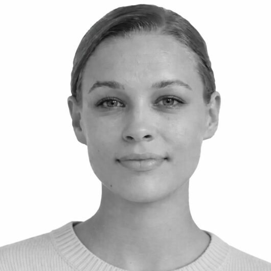 Et kvadratisk gråt panel dækker midten af ansigtet på en person med håret trukket tilbage og synlige ører; personen har en lys ribstrikket trøje og står foran en hvid baggrund.